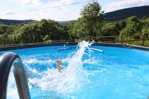 a person is splashing in a swimming pool at Domki Na Wzgórzu in Nowica