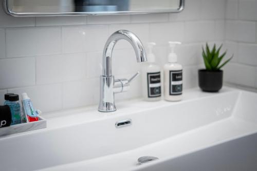 a kitchen sink with a faucet and two bottles on it at Wayzata Cove in Wayzata