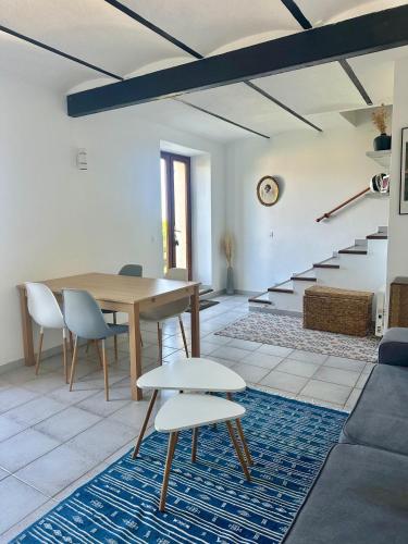 une salle à manger avec une table et des chaises et des escaliers dans l'établissement Casa Orsu vue panoramique, à Poggio-dʼOletta