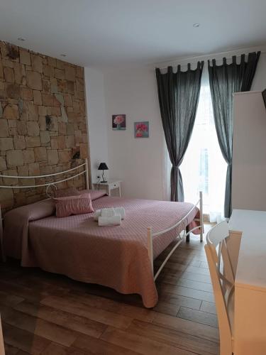 a bedroom with a bed and a brick wall at Oltremare in Cefalù