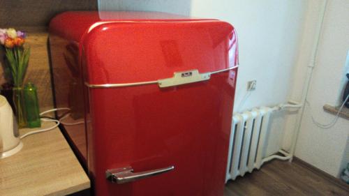 a red refrigerator in a room with a radiator at Picturesque apartment into antique fortress in Daugavpils