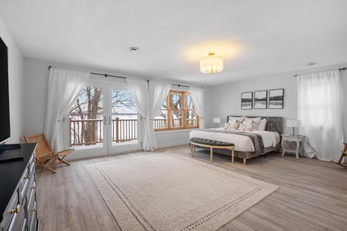 a white bedroom with a bed and a large window at Minnetonka Dream in Orono