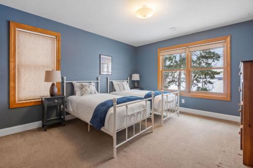 a blue bedroom with two beds and a window at Minnetonka Dream in Orono