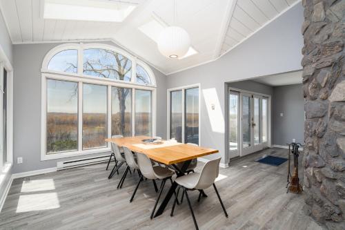 a dining room with a table and chairs and windows at Riverfront Inn in Red Wing