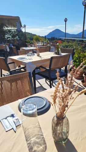 a table with plates and a vase with flowers on it at 75 Steps Apartments in Mesongi