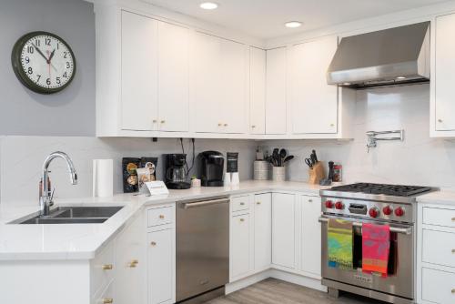 a kitchen with white cabinets and a clock on the wall at Riverfront Inn in Red Wing