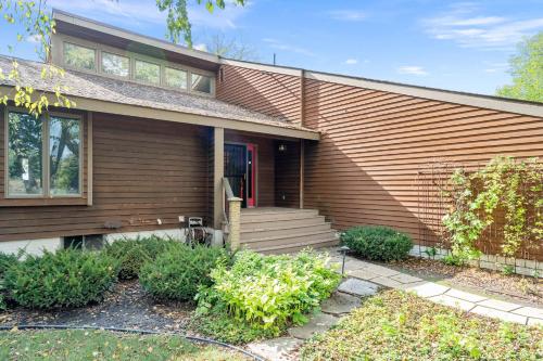 a wooden house with a red door and stairs at Riverfront Inn in Red Wing