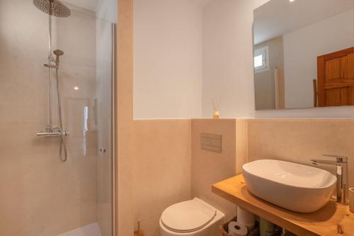 サン・ホアン・デ・ラブリチャにあるCan Joan Durbanの洗面台、トイレ、鏡のあるバスルーム