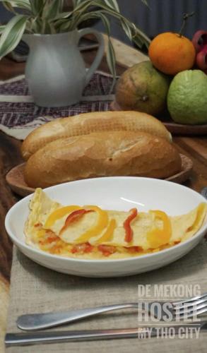 Un plato de comida con pan en una mesa. en DE MEKONG HOSTEL MY THO City, en Mỹ Tho