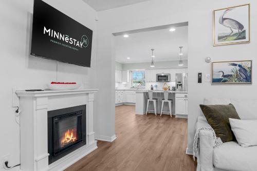 a living room with a fireplace and a kitchen at The Orchard in Hugo