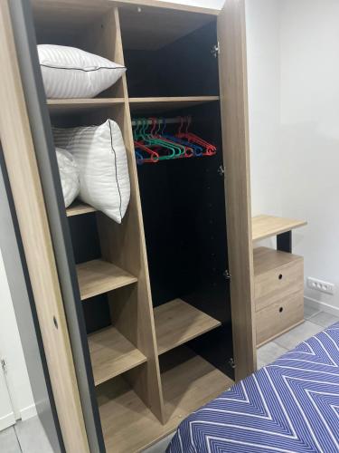 a closet with wooden shelves and pillows at L'écrin du Bonheur in Saint-Bardoux