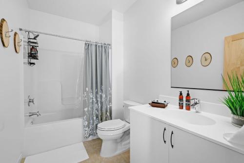 a white bathroom with a toilet and a shower at The Happy Home in Lakeland