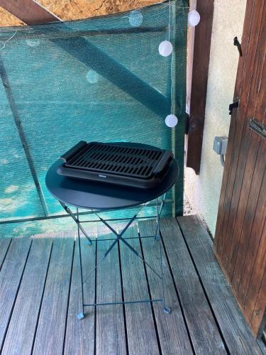 un ordinateur portable assis sur une table en verre sur une terrasse dans l'établissement L'écrin du Bonheur, à Saint-Bardoux