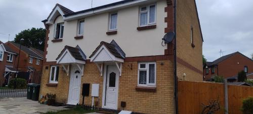 a white house with black roofs on the side of it at Entire 2 bedroom home with parking in Coventry, UK in Coventry