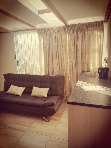 a couch sitting in a living room with a window at Klagesoek in Vosburg