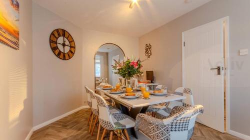 a dining room with a table with chairs and a clock at Pet-Friendly Coastal Home by Adliv in Broadstairs