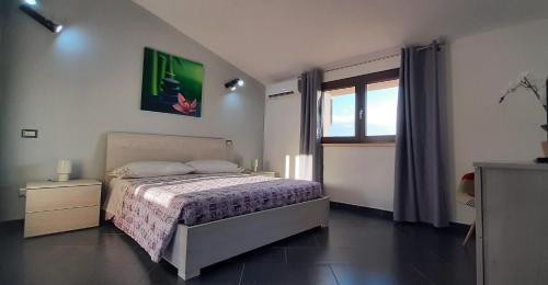 a bedroom with a bed and a large window at House Sa Sedda in Carbonia