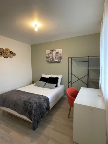 une chambre avec un lit et une chaise rouge dans l'établissement Colorino - T4 Lumineux Cosy, Parking Gratuit, Commerces, à Saint-Brieuc