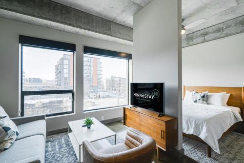 Un dormitorio con una cama, un televisor y un sofá. en Sable 302 - Alcove, en Minneapolis