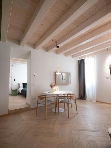 a dining room with a table and a bedroom at PALAZZO CIOPETA - Italian Excellence in Verona