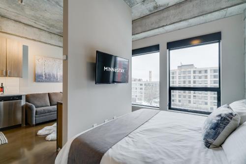 Un dormitorio con una cama grande con un televisor en la pared. en Sable 507 - Alcove, en Minneapolis
