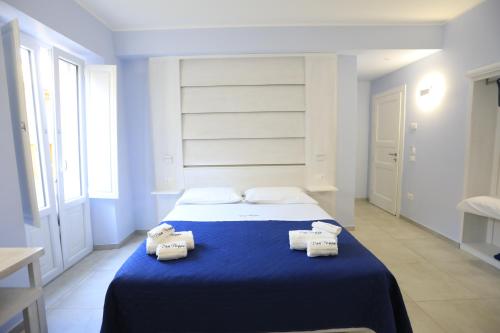 a bedroom with a blue bed with towels on it at Don Peppe Rooms With Beach Service Included in Tropea
