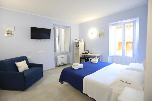 a bedroom with a bed and a blue chair at Don Peppe Rooms With Beach Service Included in Tropea