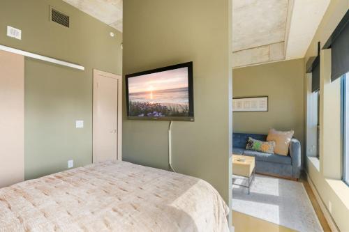 Un dormitorio con una cama y un televisor en la pared. en Sable 601 - Alcove, en Minneapolis