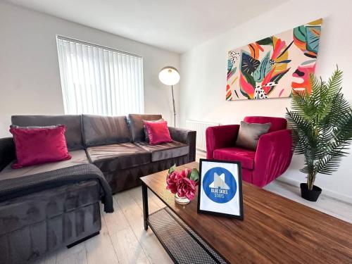 a living room with a couch and two red chairs at Ayresome House By Blue Skies Stays in Middlesbrough