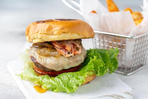 a sandwich with meat and lettuce and a basket of fries at Pumilio Mountain & Ocean Hotel in Jacó