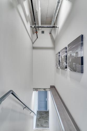 a staircase in a white room with two pictures on the wall at Sable 701 - Luxury Two Story Loft in Minneapolis