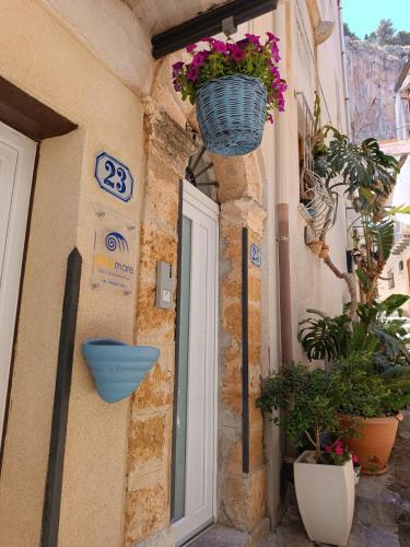 a door with a basket of flowers on the side of a building at Oltremare in Cefalù