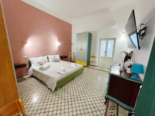 ein Schlafzimmer mit einem Bett und einem Fernseher darin in der Unterkunft MOH - Casa Maga in Grottaglie