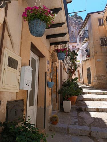 an alley with flower baskets on the side of a building at Oltremare in Cefalù