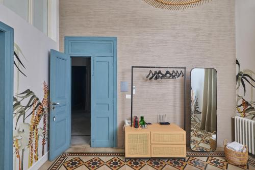 a hallway with a blue door and a mirror at Beit Tamanna Guesthouse in Beirut