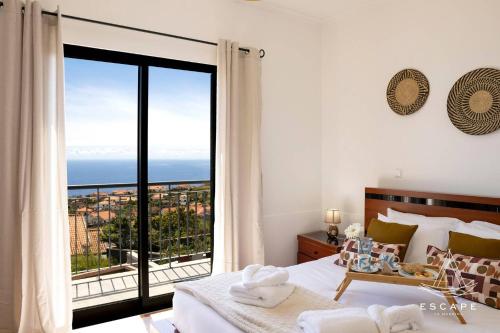 a bedroom with a bed with a view of the ocean at Villa Izilda by ESCAPE to Madeira in Ponta do Sol