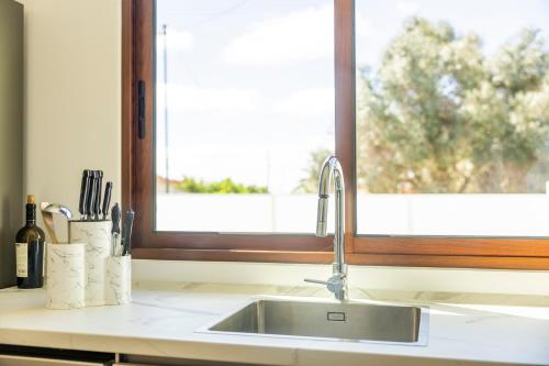 eine Küchentheke mit Spüle und Fenster in der Unterkunft Green House Beach Side Oasis in Vila Baleira