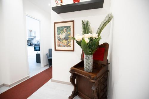 a vase of flowers on a table in a hallway at Catania Over Time - Tourist Rooms in Catania