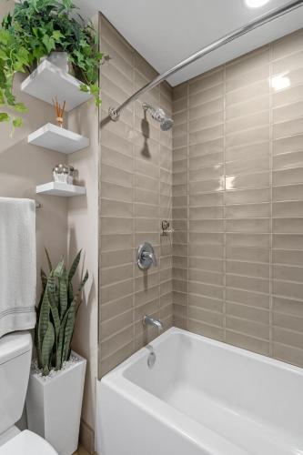 a bathroom with a tub and a toilet and a plant at Sable 804 - One Bedroom in Minneapolis