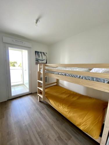 deux lits superposés dans une chambre avec fenêtre dans l'établissement Appartement Neuf, Plage & Centre-Ville à Pied, à Lacanau