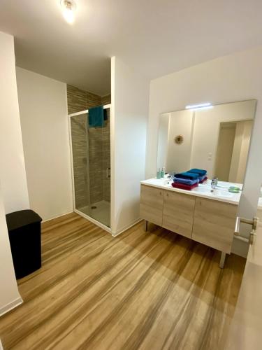 une salle de bain avec un lavabo et une douche dans l'établissement Appartement Neuf, Plage & Centre-Ville à Pied, à Lacanau