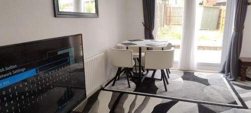 a room with a table and two chairs and a television at Entire 2 bedroom home with parking in Coventry, UK in Coventry