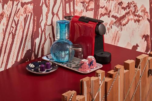 a red table with a coffee maker and a tray of items at Beit Tamanna Guesthouse in Beirut