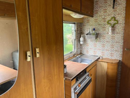 une petite cuisine avec un évier et une fenêtre dans l'établissement Séjour Bien Être nature, à Perrecy-les-Forges