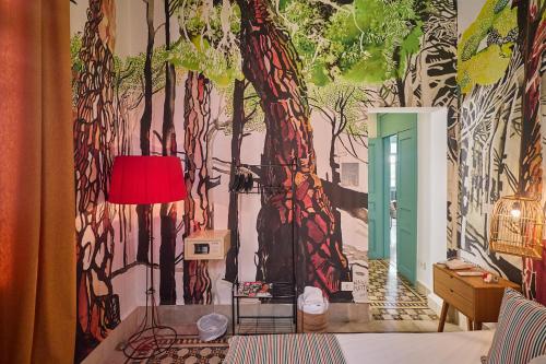 a room with a wall with a tree mural at Beit Tamanna Guesthouse in Beirut