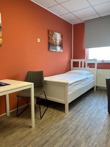 a bedroom with a bed and a desk and a table at Hostel Apartment in Castrop-Rauxel