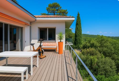 une terrasse en bois avec une table et un banc dans l'établissement Un havre de paix sur le Golf International d'Arcachon - vue imprenable, à La Teste-de-Buch