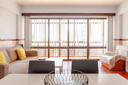 a living room with a couch and a table at Casa na Praia in Sesimbra