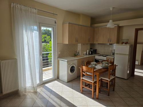a kitchen with a table and a stove and a refrigerator at Garden apartment 20m from the sea in Kírra