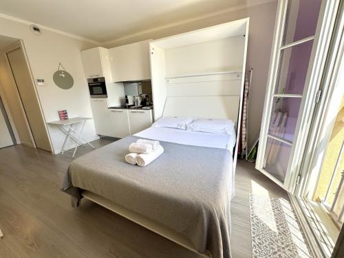 a bedroom with a bed with towels on it at ApartHotel Riviera Nice Côte d'Azur - Old Town - Studio AC - Sea View - 50m Promenade des Anglais- LA MAISON LINDA in Nice